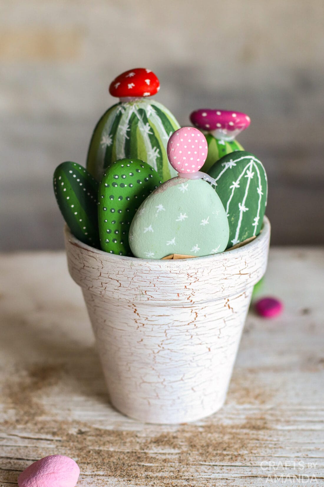 Clay pot filled with various rocks painted to look like cactuses