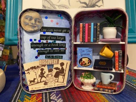 homemade miniature bookshelf inside altoid tin