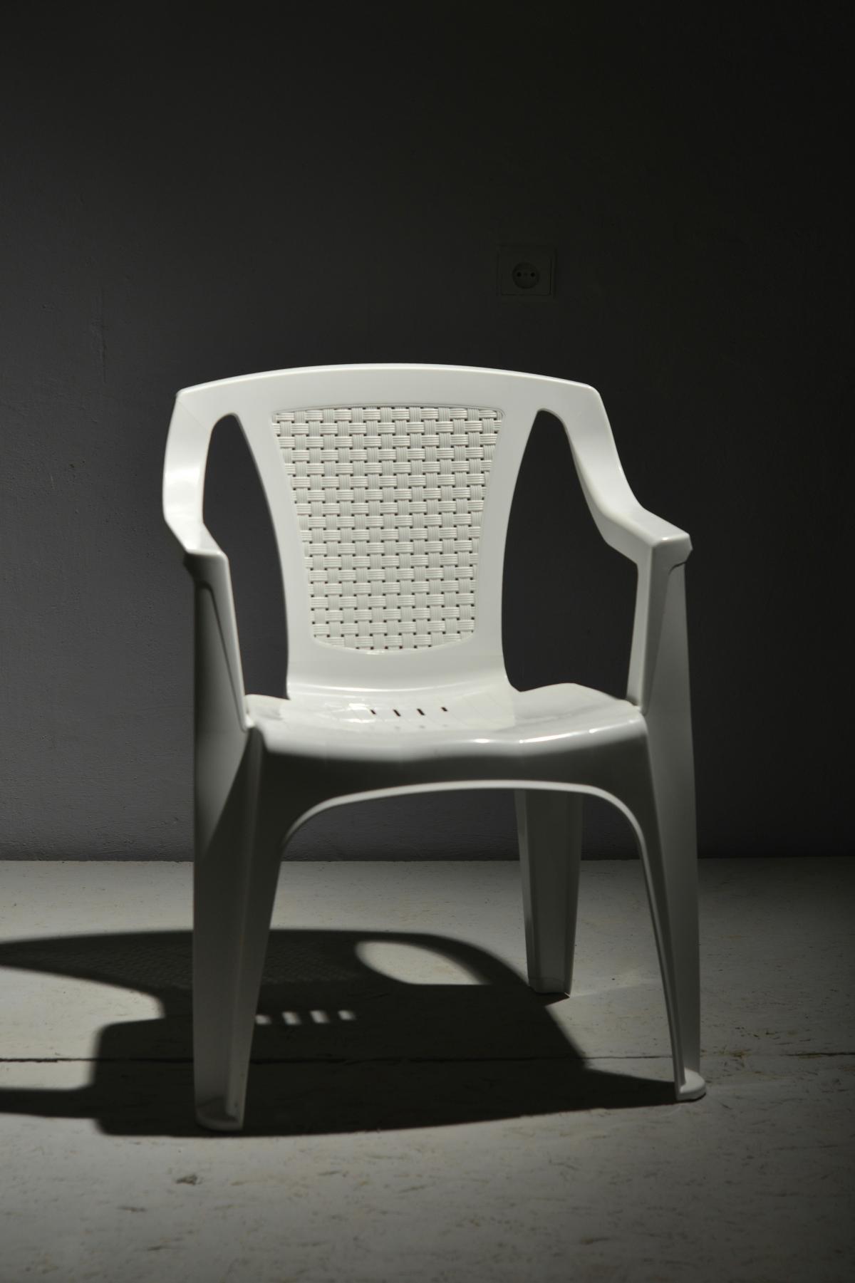 White chair, dark background. 